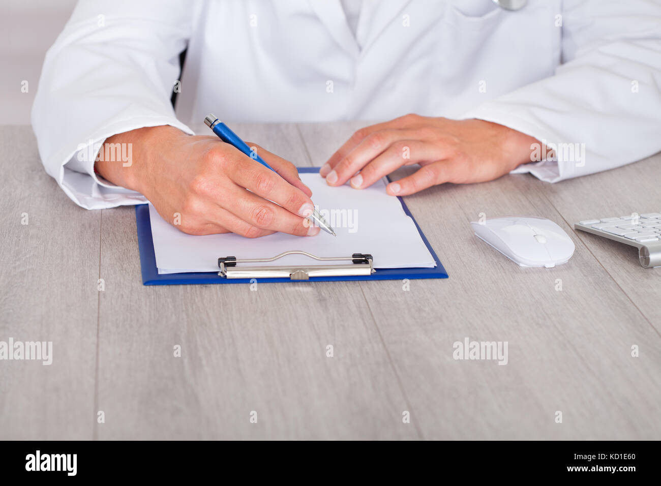 Close-up Of Male Doctor's Hand Filling Forms Stock Photo