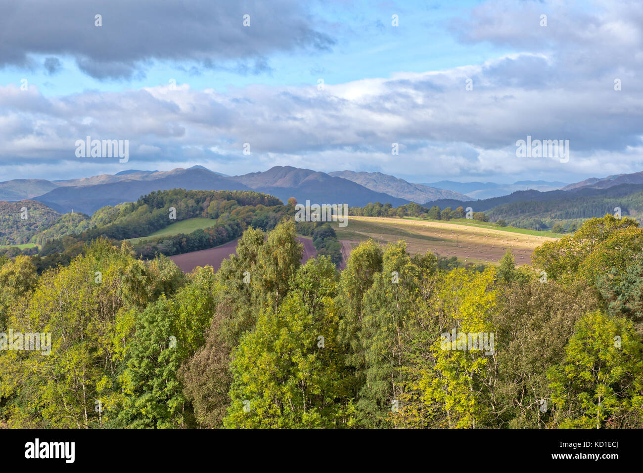 Crieff at the start of autumn with the hillside and Ben Chonzie in the distance looking over the tree tops from Knock Hill in Crieff above the town. Stock Photo