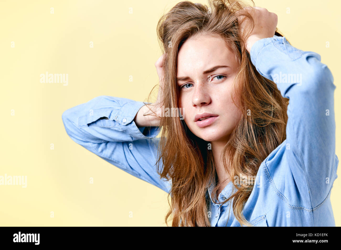 Young distraught redhead teenager with freckles pulling her hair. Tired ...