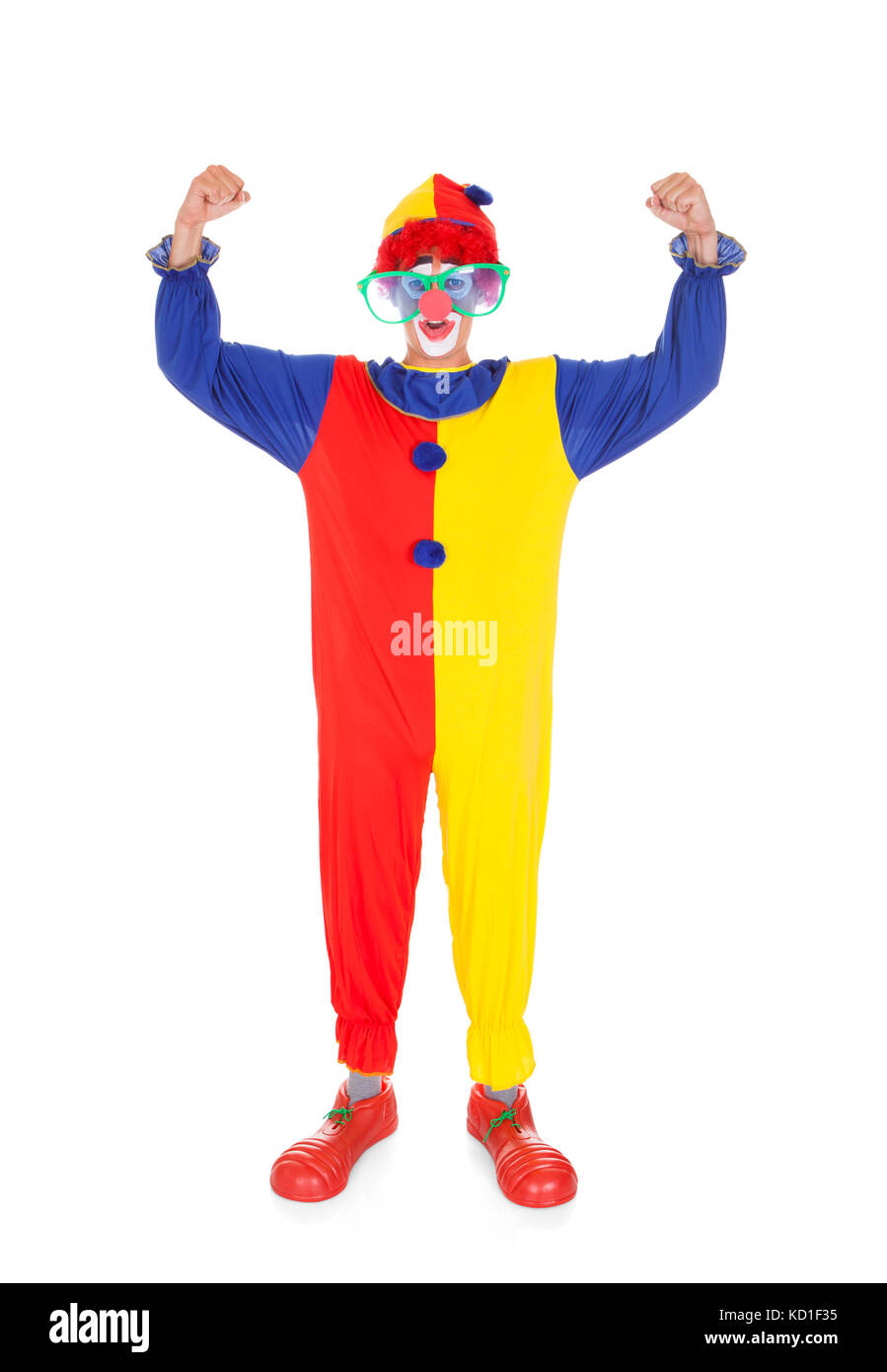 Portrait Of A Happy Joker Clenching His Fist Over White Background Stock Photo