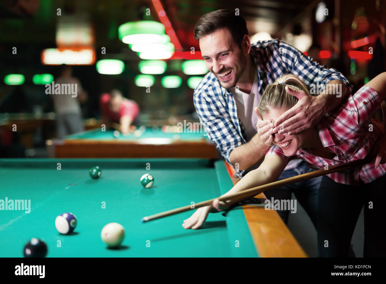 Young couple playing together pool in bar Stock Photo