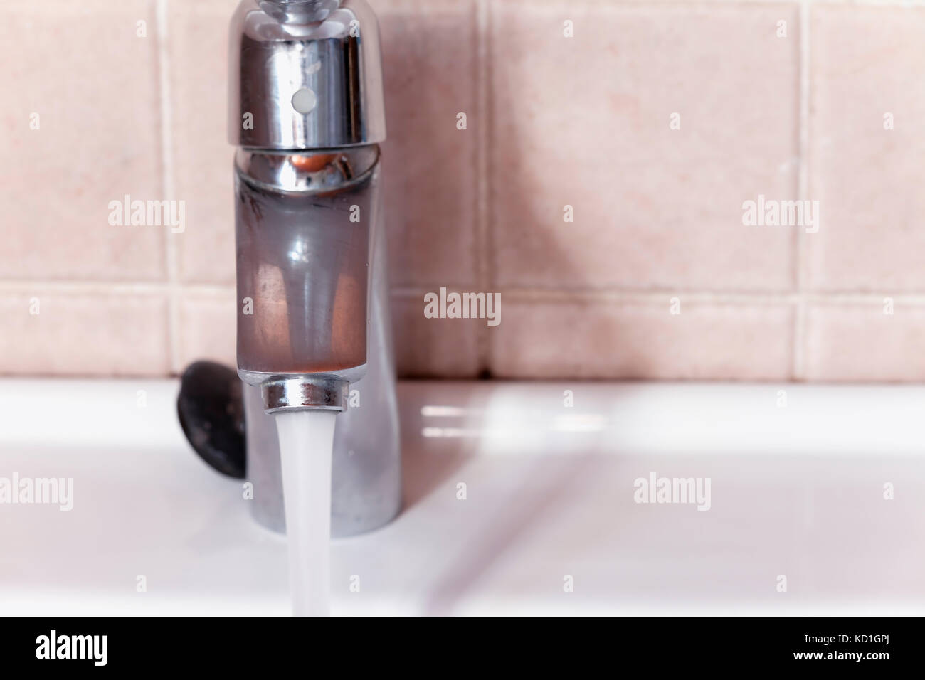 Open faucet letting the water run. Stock Photo