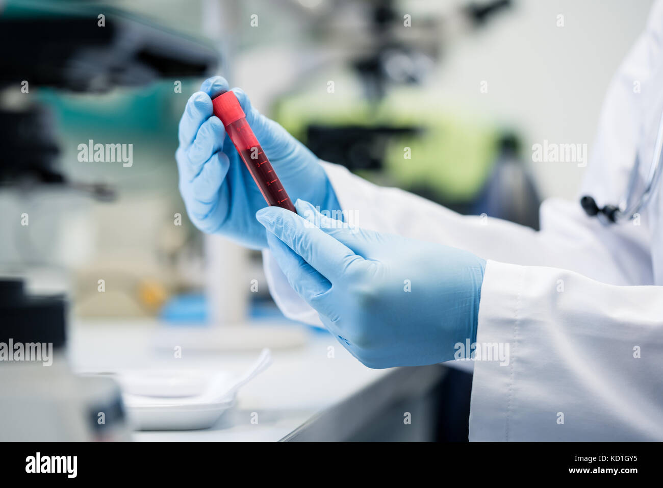 Scientist in biological lab holding blood test in hand Stock Photo Alamy