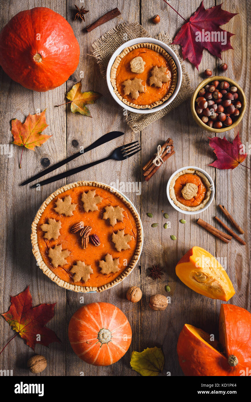 Homemade Pumpkin pie for Thanksgiving dinner on wooden table with holiday decorations. Table top view. Autumn food, Thanksgiving day food Stock Photo
