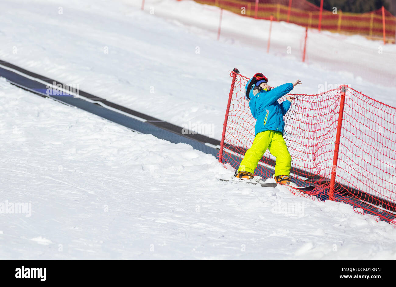 Little boy falling down while skiing in children's area on winter resort Stock Photo