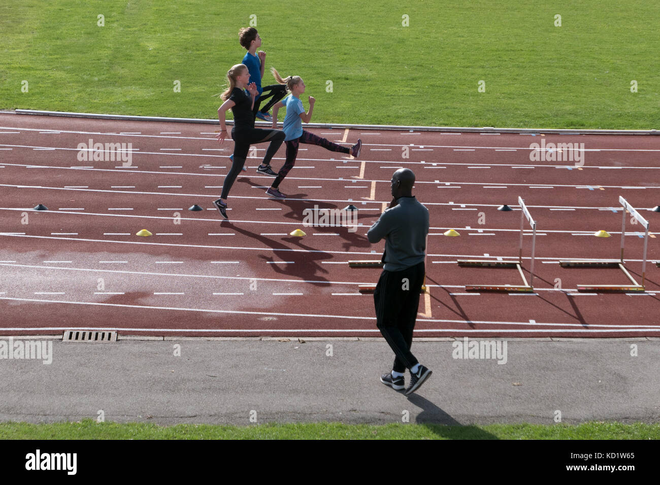 Three young athletes in training for hurdles race Stock Photo Alamy