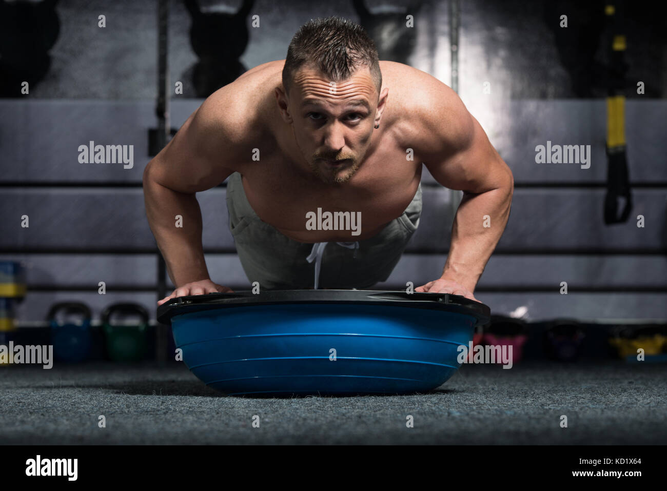 Personal Trainer Doing Pushups On Floor With Bosu Balance Ball As Part
