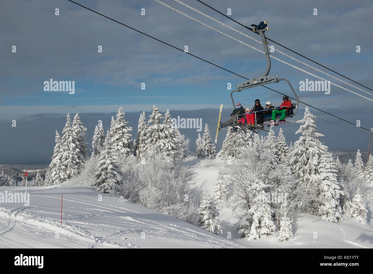 Skiers in a chairlift heading towards Mont-Rond, Jura, Ain Rhone-Alpes, France Stock Photo