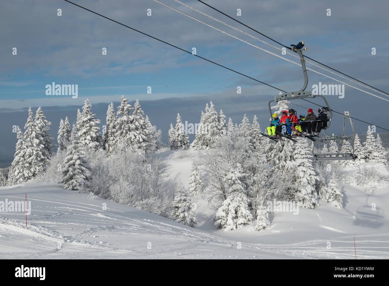 Skiers in a chairlift heading towards Mont-Rond, Jura, Ain Rhone-Alpes, France Stock Photo