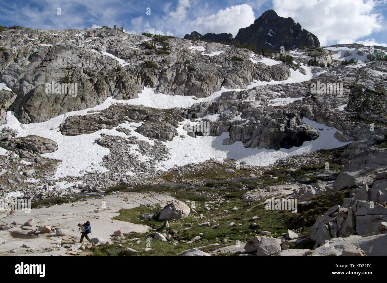 A backpacker travels along alpine high country on the John Muir Trail in Kings Canyon National Park California Stock Photo