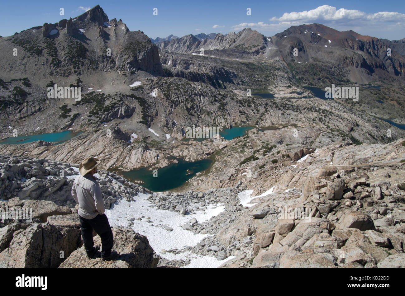 A hiker overlooks Conness Lakes and North Peak in Harvey Monroe Hall Research Natural Area along the boarder of Yosemite National Park Wilderness Stock Photo