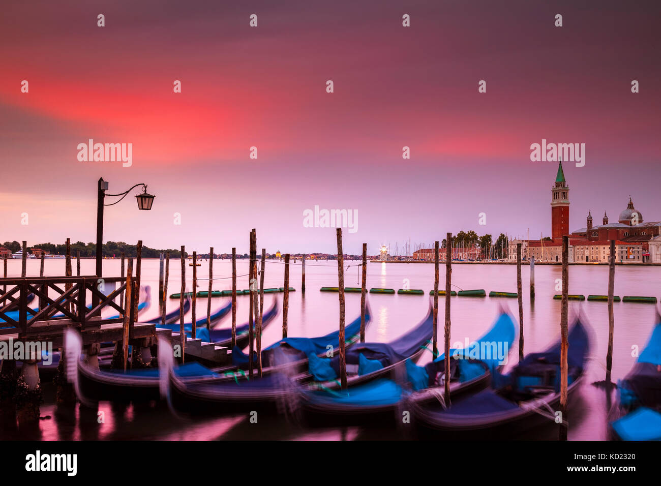 Dramatic sunrise over Venice, Italy. In the foreground are the iconic gondolas and across the canal is the island of San Giorgio Maggiore. Stock Photo
