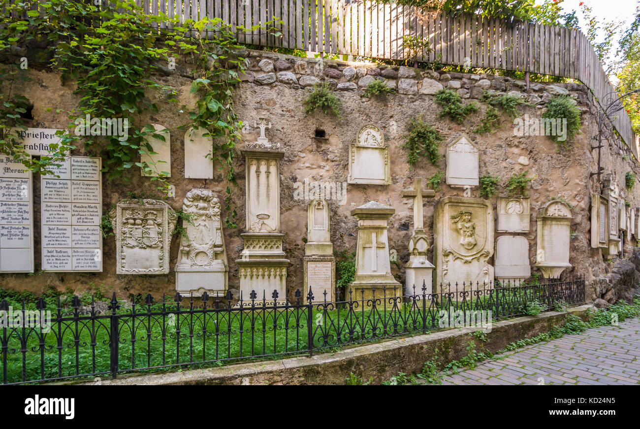 external tombstones, mostly dating back to the 16th century affixed to the walls at the Cathedral of Meran, South Tyrol, northern Italy Stock Photo
