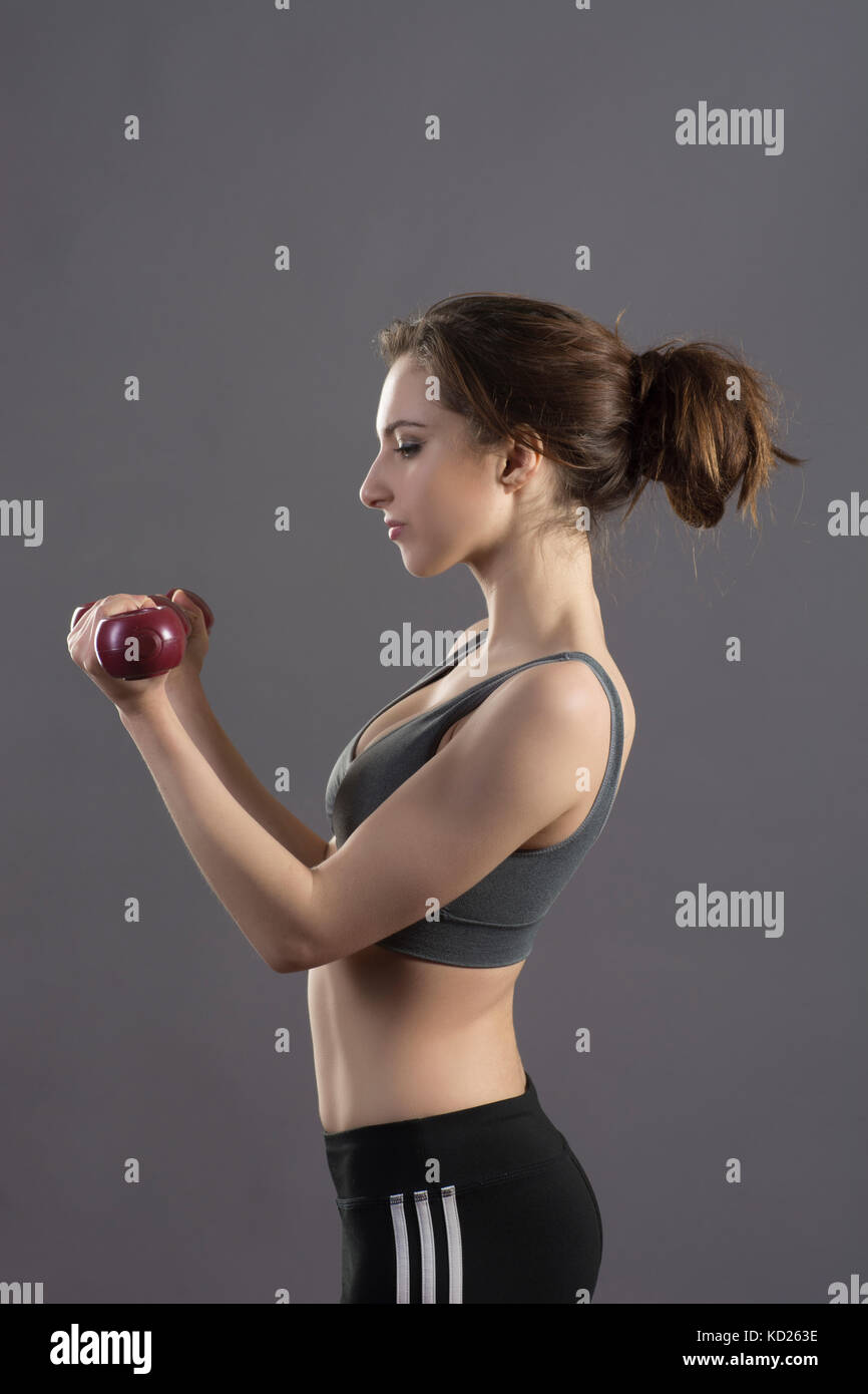 Side view of a young woman exercising with weights Stock Photo