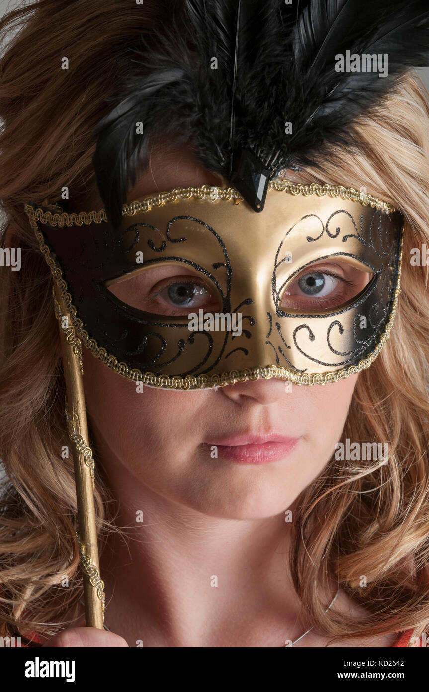 Portrait of a blonde woman wearing a Venetian mask Stock Photo