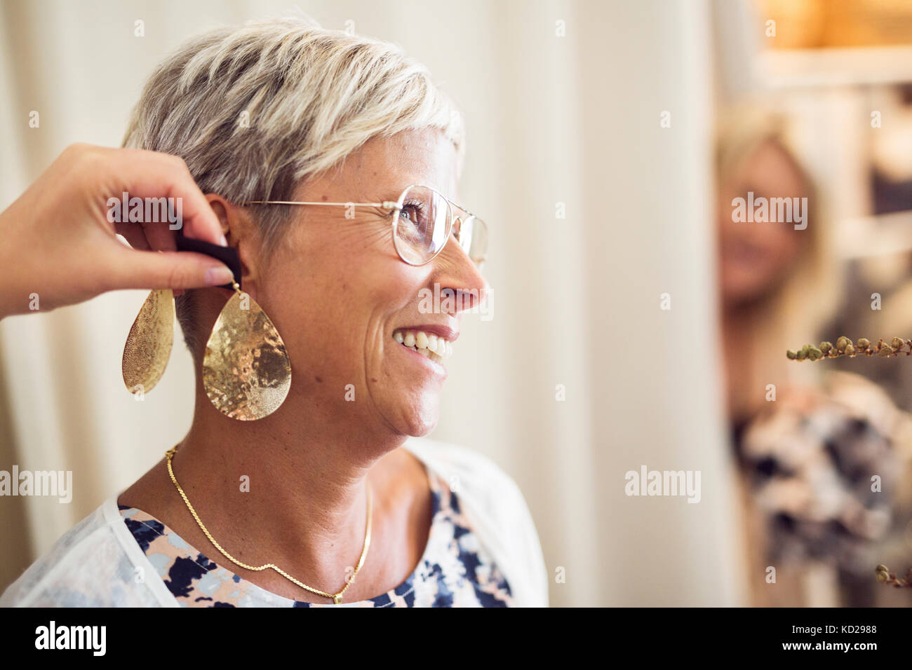 Woman trying earrings Stock Photo Alamy