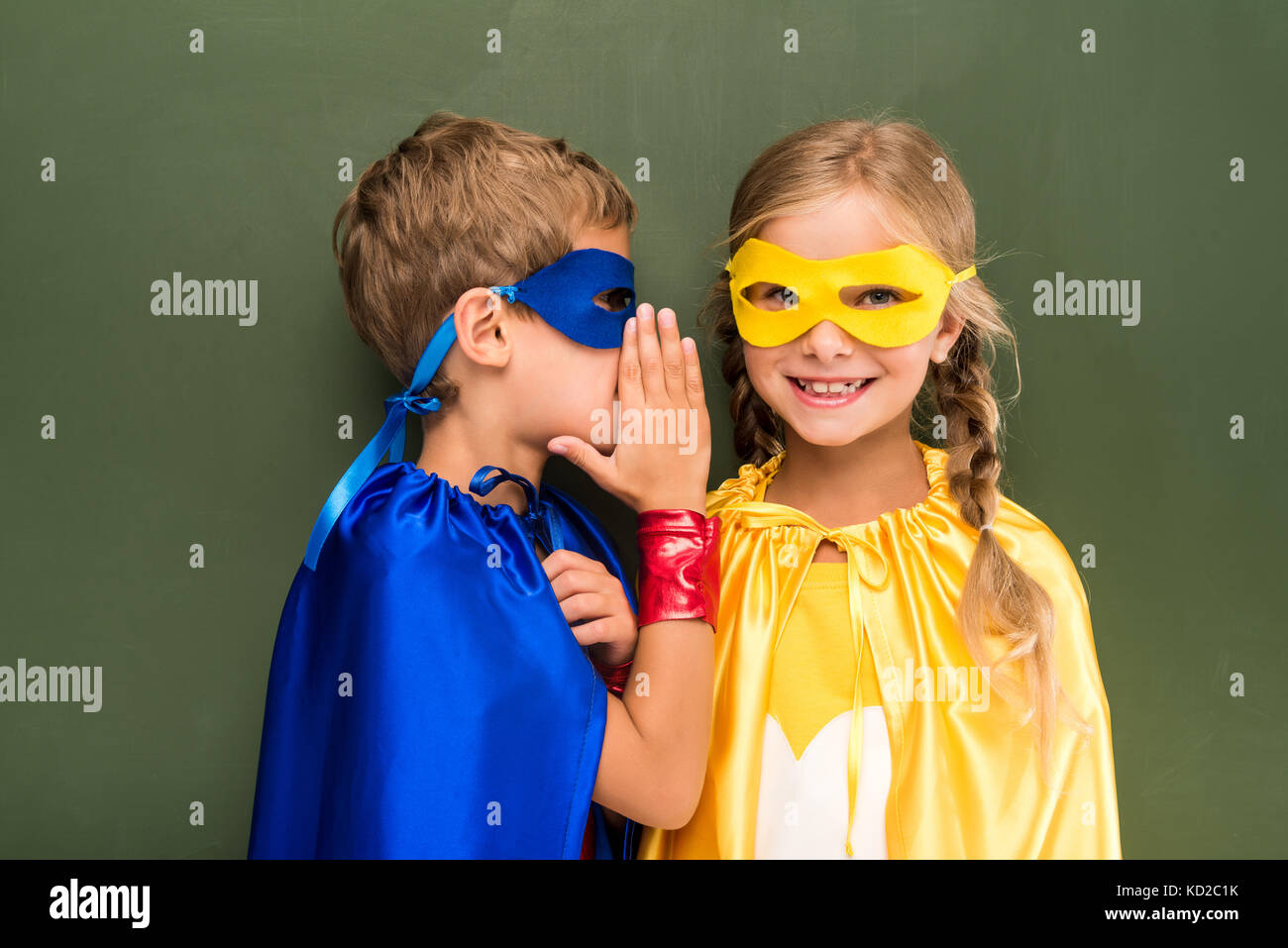 gossiping pupils in superhero costumes  Stock Photo