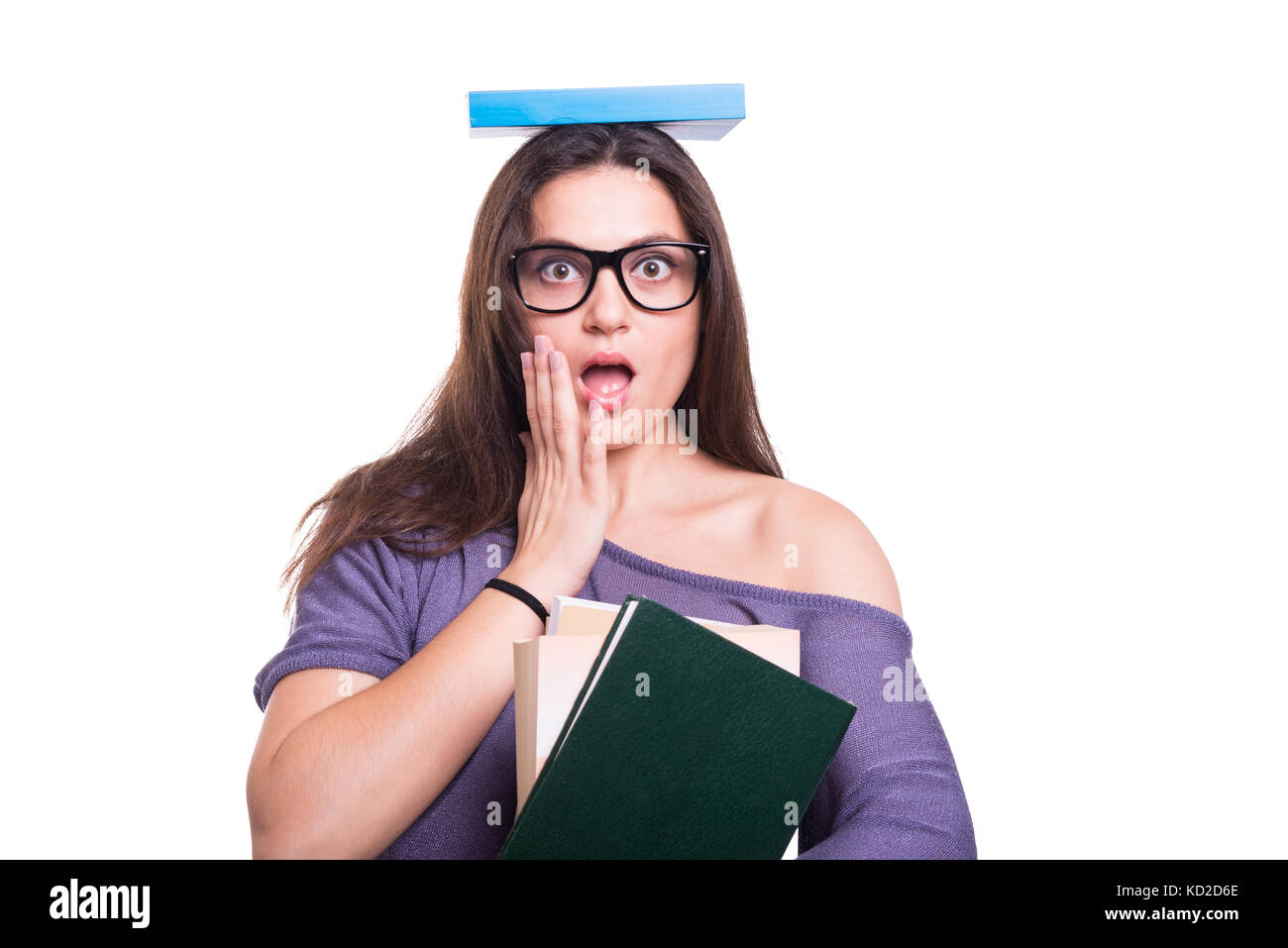Young amazed girl with book over her head isolated on white background ...