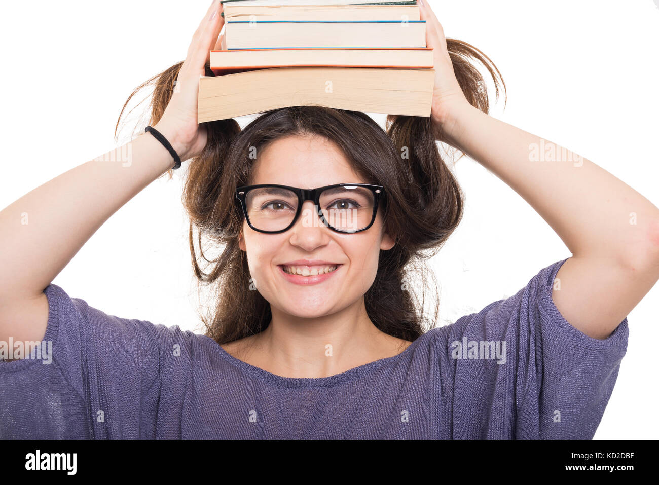 Funny young student with books on her head smiling on white background ...