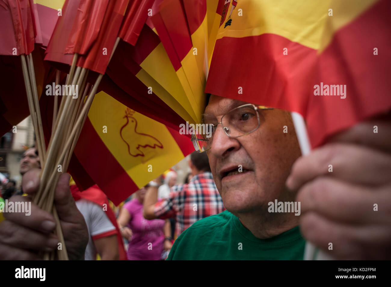 A man distributes flags of Spain in an anti-independence concentration, Barcelona. Credit: Alamy / Carles Desfilis Stock Photo