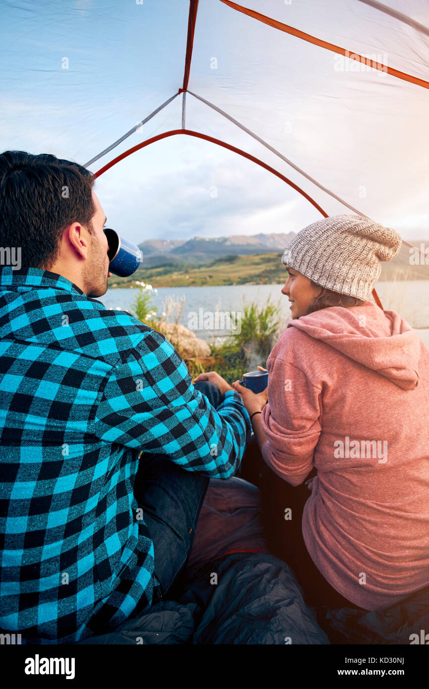 Couple sitting in tent, drinking hot drinks, looking out at view, Heeney, Colorado, United States Stock Photo