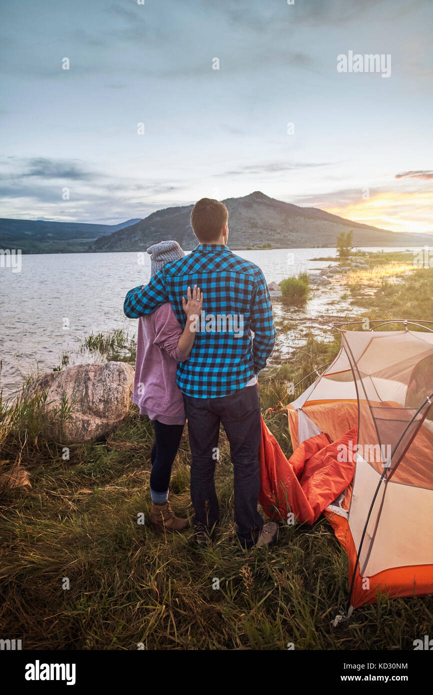 Couple standing beside tent, looking at view, Heeney, Colorado, United States Stock Photo
