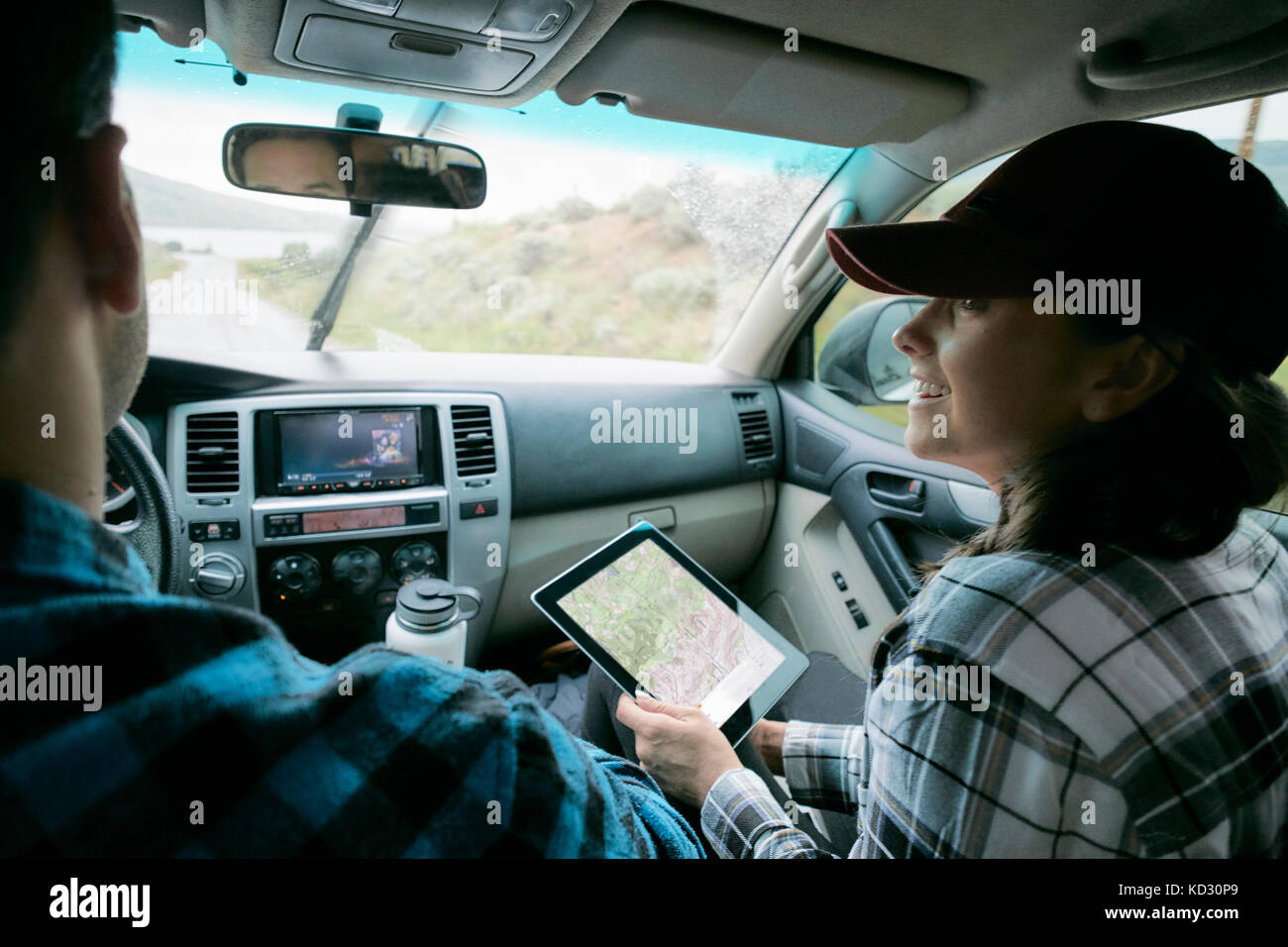 Couple in car, woman holding digital tablet with map showing Stock Photo