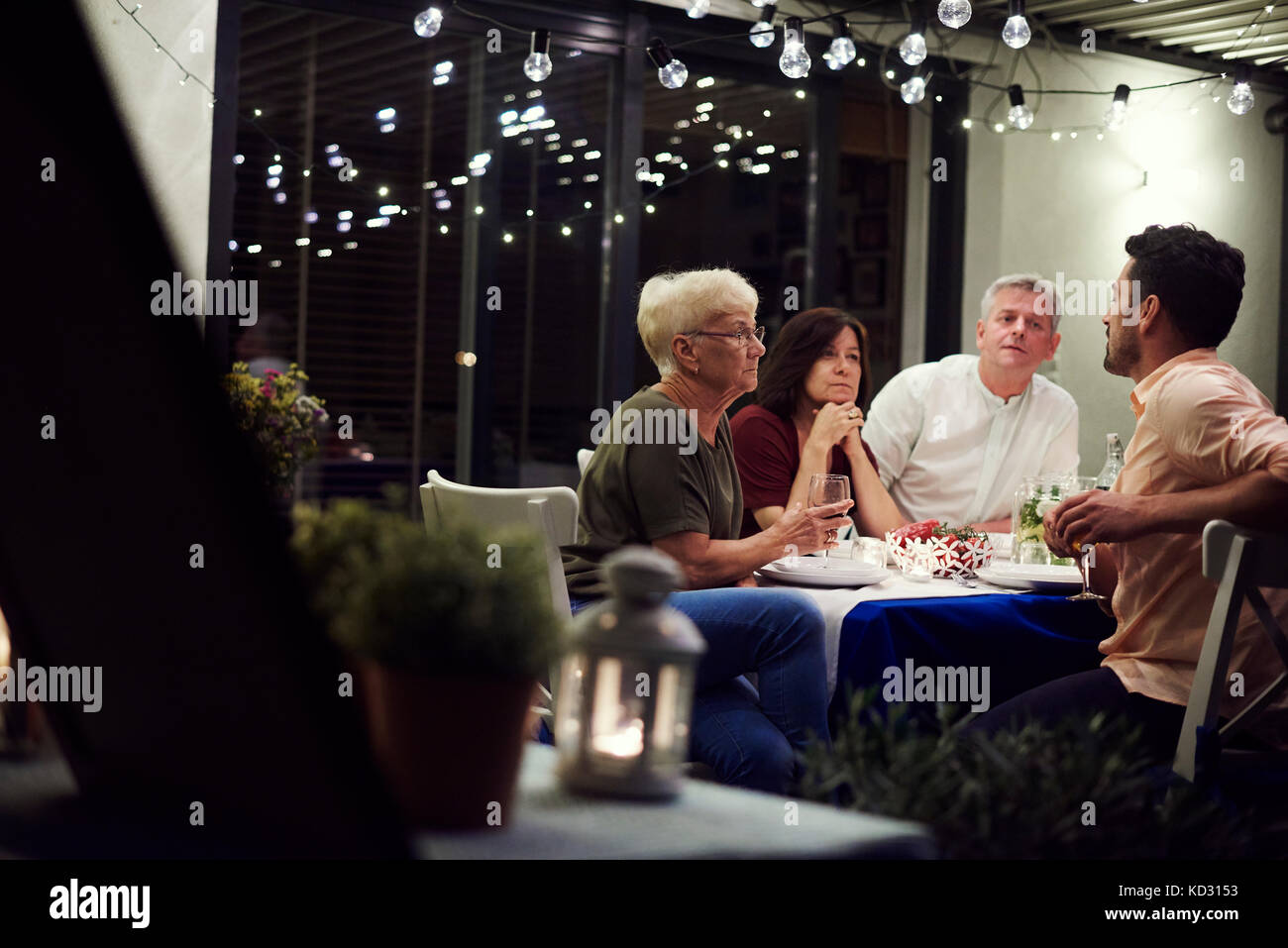 Group of people sitting at table, enjoying meal Stock Photo