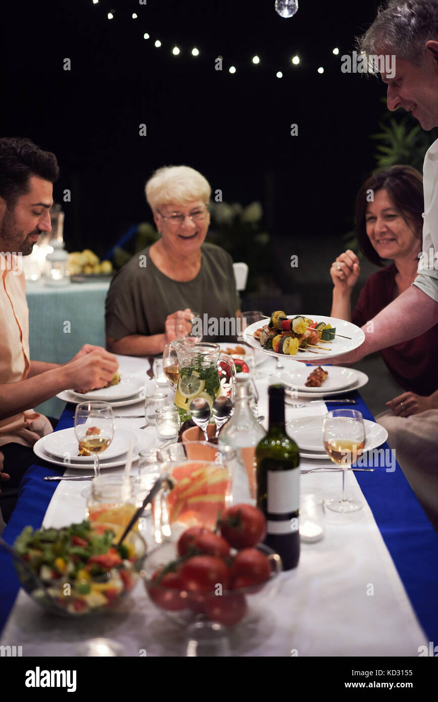 Group of people sitting at table, enjoying meal Stock Photo