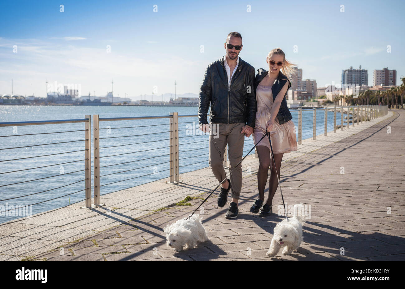 Couple walking dogs on promenade, Cagliari, Sardinia, Italy, Europe Stock Photo
