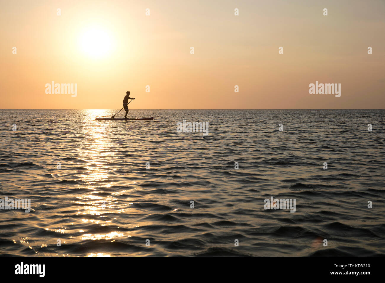 Man on paddleboard at sunset, Kilindoni, Pwani, Tanzania, Africa Stock Photo