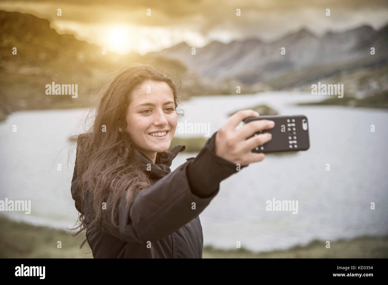 Teenage girl taking selfie in front of lake smiling, San Bernardino, Ticino, Switzerland, Europe Stock Photo