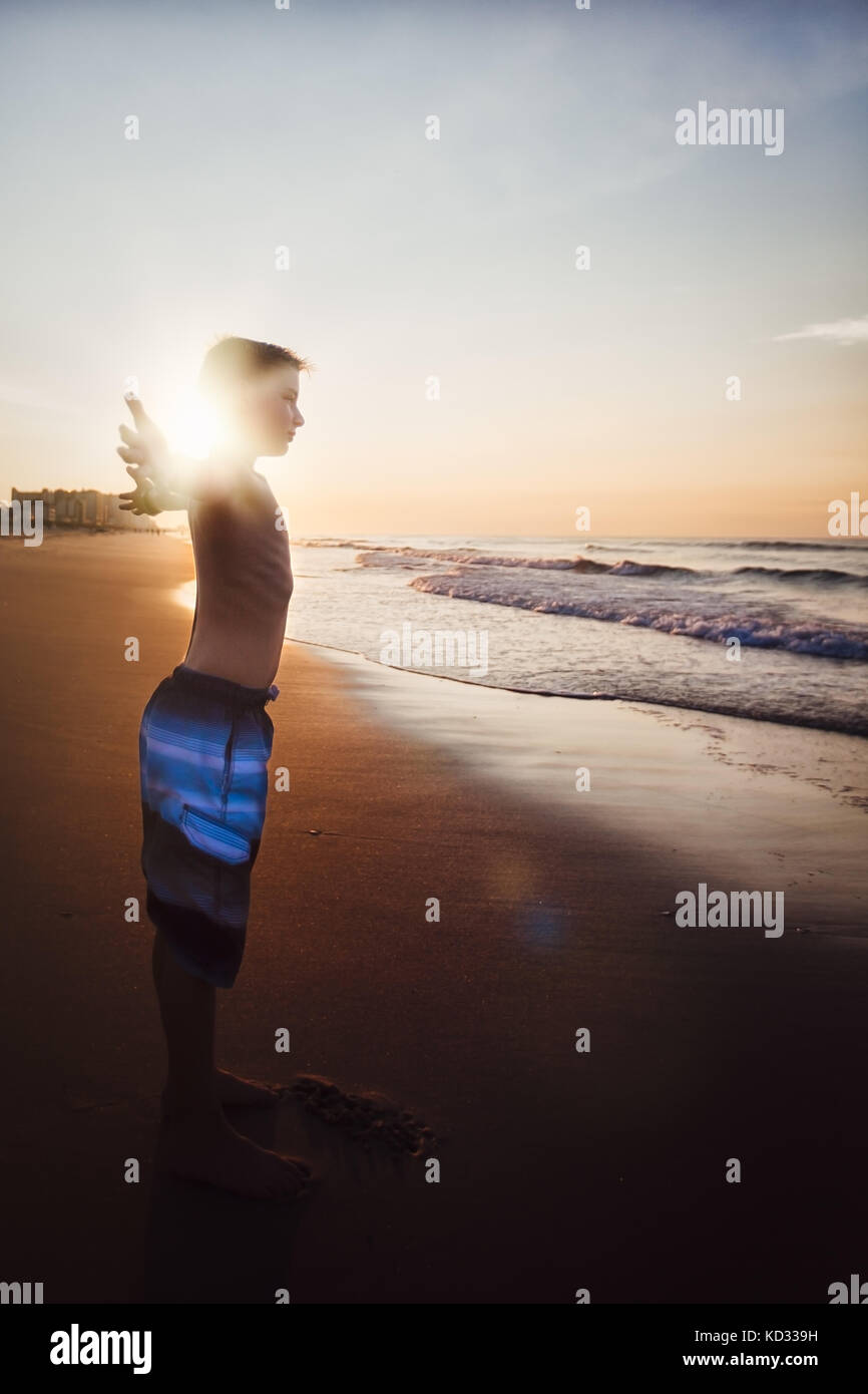 Boy stretching on beach Stock Photo