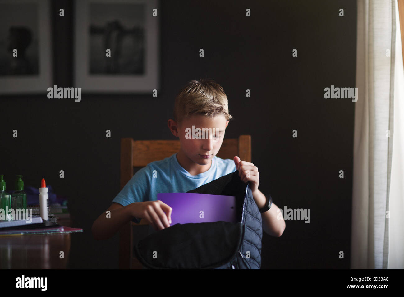 Boy packing backpack with school stationery supplies Stock Photo