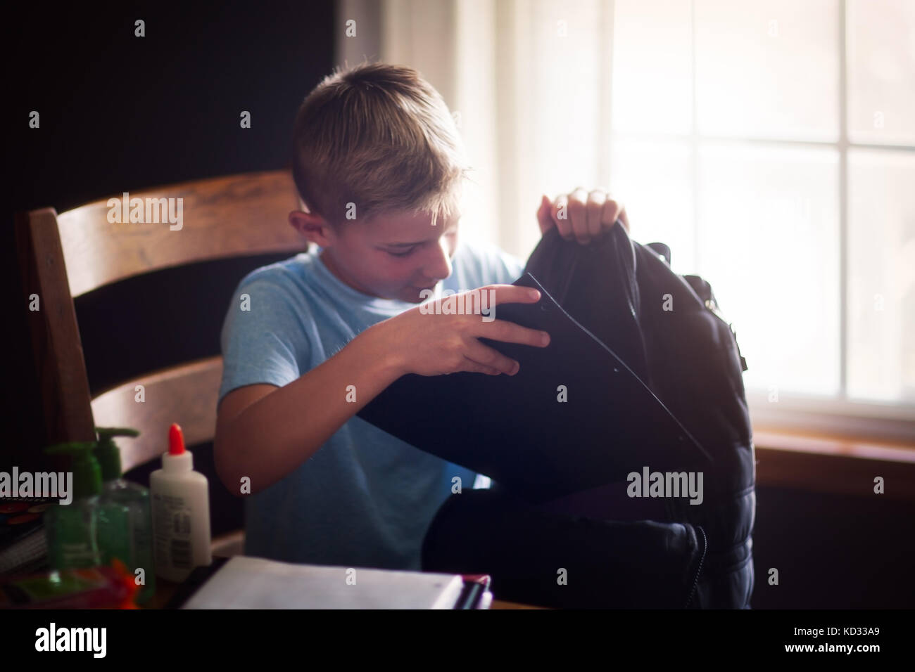 Boy packing backpack with school stationery supplies Stock Photo