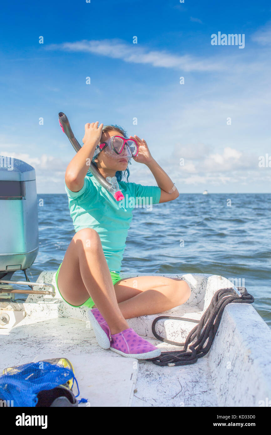 Girl fitting on diving mask on boat Stock Photo