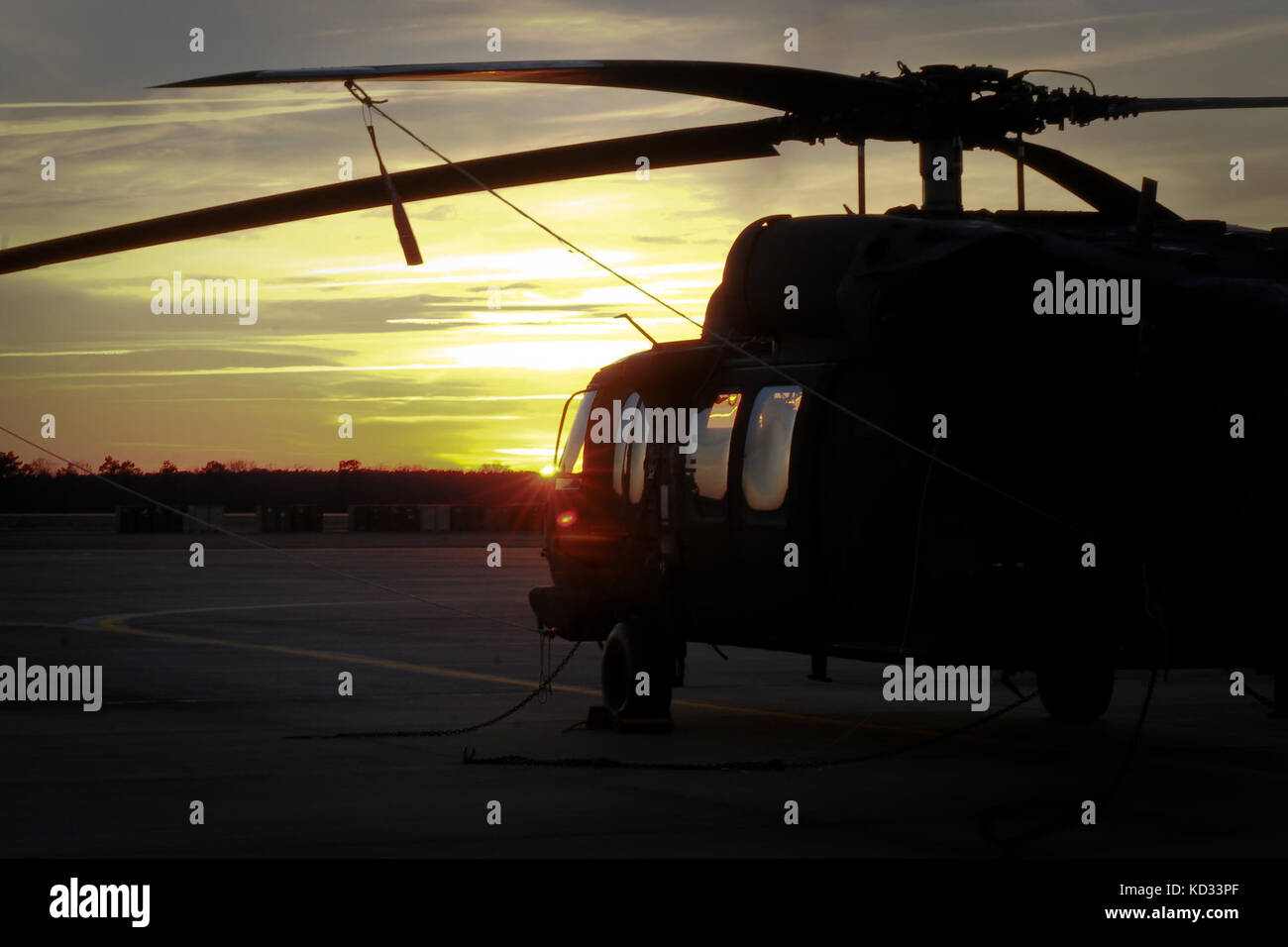 Aircrews have returned from their training missions and UH-60 Black Hawks are secured on the flight line as the sun begins to set at the end of the training day at McEntire Joint National Guard Base, in Eastover, S.C. on Jan. 10, 2015. (U.S. Army National Guard photo by Sgt. Brian Calhoun/Released) Stock Photo