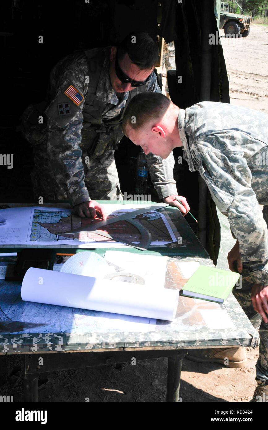Staff Sgt. James Langille, fire direction control sergeant, and Spc. Timothy Dietrich, fire direction control specialist, in the 178th Field Artillery Battalion, South Carolina Army National Guard, manually plot the direction and range to their target during their annual training on the firing ranges at Fort Stewart, GA. The 178th focus for training is on manual gunnery, a skill seldom used with today’s technology, but very important for when computers go down and technology doesn't work. (U.S. Army National Guard photo by OC Tracci Dorgan/Released) Stock Photo