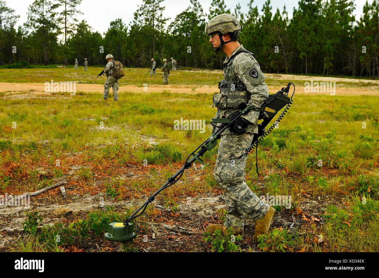 U.S. Army Spc. Michael Tingen, assigned to 1221st Route Clearance Company, South Carolina Army National Guard, sweeps for possible improvised explosive device during a dismounted patrol-training scenario at McCrady Training Center, Eastover, S.C., June 24, 2014.  Tingen’s mission is to locate command wires to improvised explosive devices and provide security in case of an attack.  (U.S. Air National Guard photo by Tech. Sgt. Jorge Intriago/Released) Stock Photo