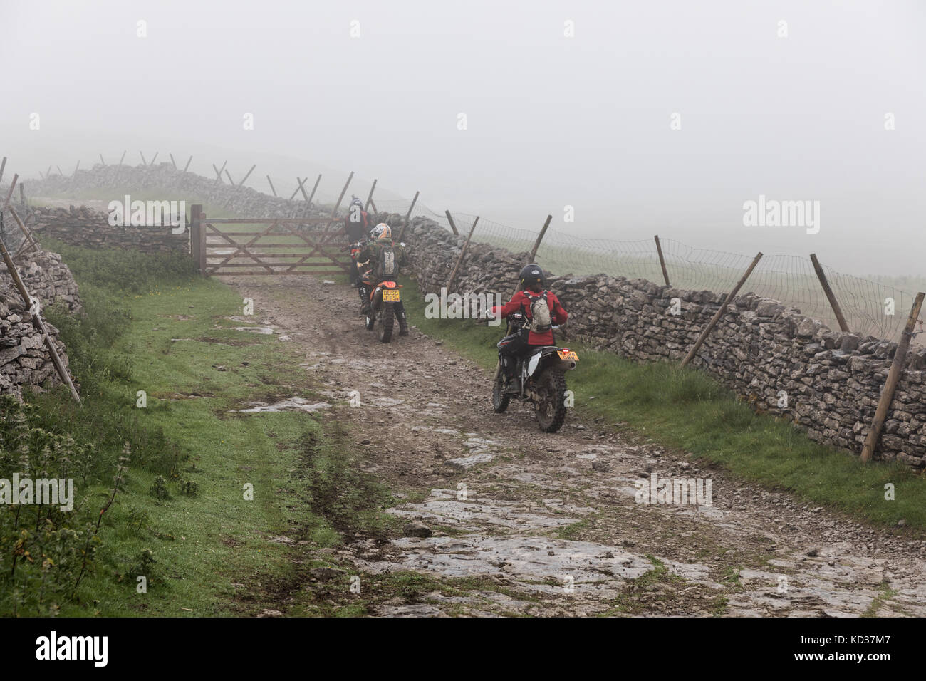 Motorcyclists on a misty day on Cam High Road, an ancient Roman route, in the Yorkshire Dales. The green lane is a byway open to all traffic Stock Photo