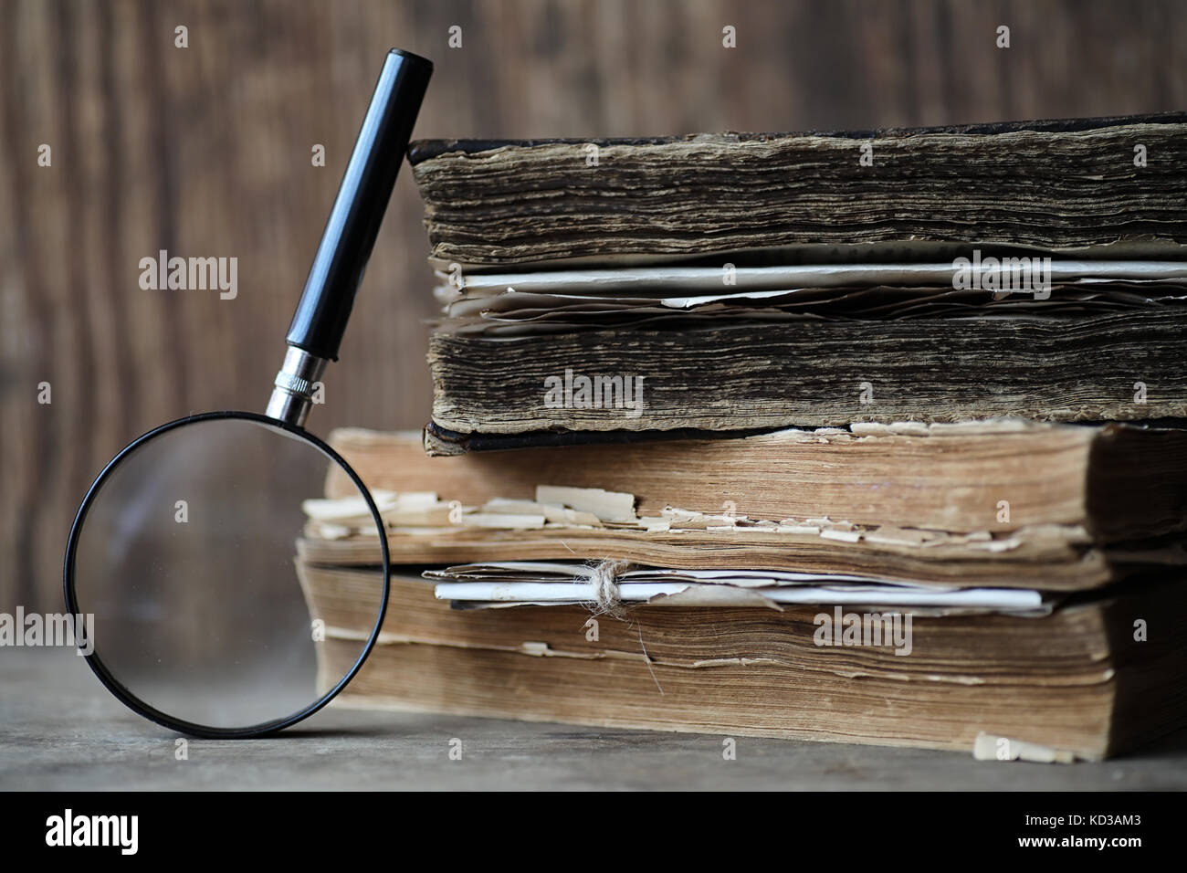 Old books on a wooden table and magnifier Stock Photo - Alamy