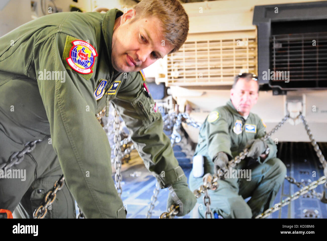 Senior Master Sgt. Matt Youngerman, Loadmaster Superintendent for the 315th Airlift Control Flight, secures a M1A1SA Abram using heavy-duty chains aboard a C-17 prior to flight. The South Carolina Army National Guard’s 1-118th Combined Arms Battalion (CAB) participates in heavy airlift operations April 10-11, 2014 at Wright Army Airfield (WAAF), Hinesville, Ga., to demonstrate the joint, total force, capabilities of the S.C. Army Guard and U.S. Air Force Reserve’s 315th Airlift Wing.  Soldiers and Airmen worked in unison over two days to load and secure four of the 1-118th CAB’s new M1A1SA Abr Stock Photo