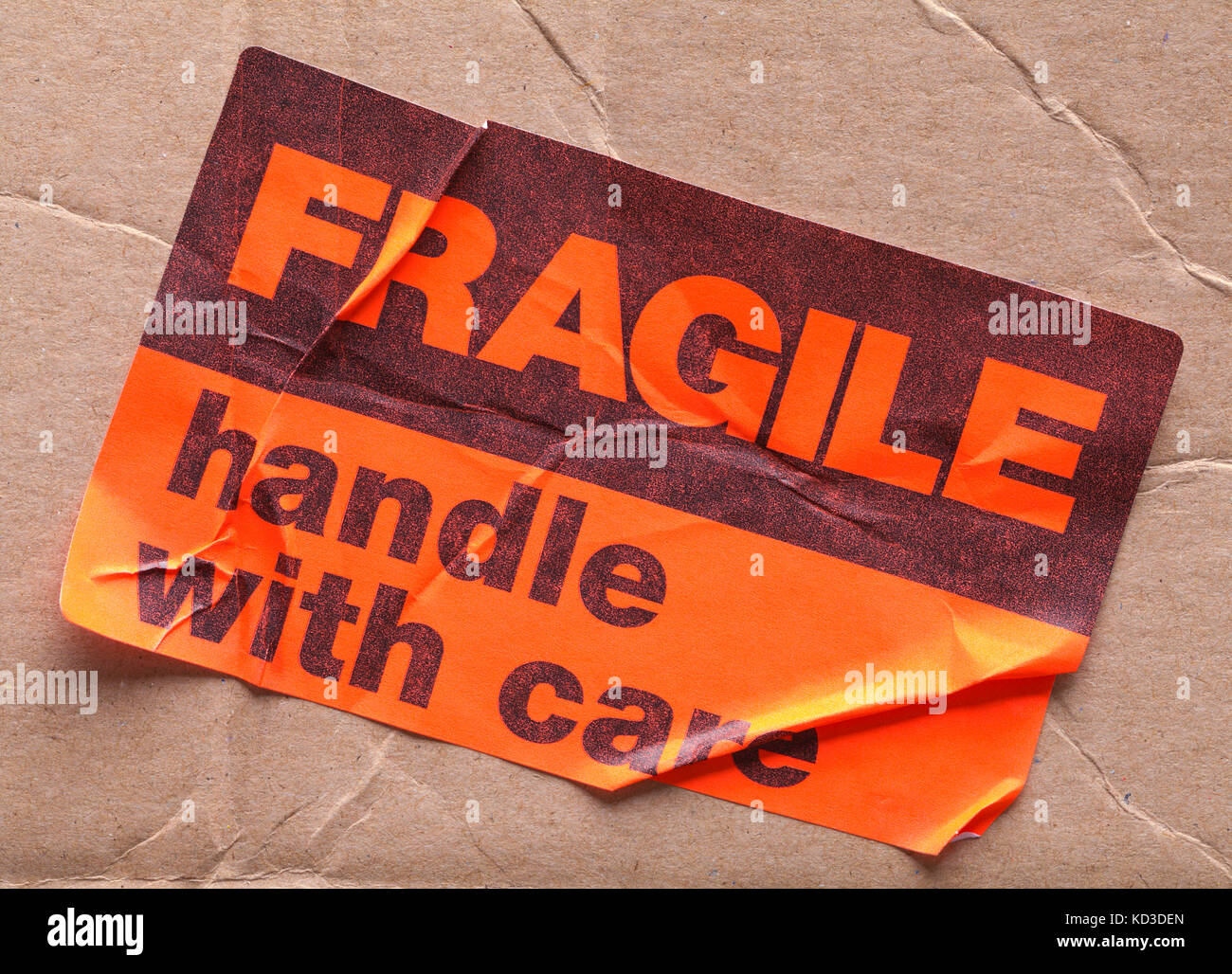Fragile Sticker on Bent Up Box Isolated on a White Background. Stock Photo