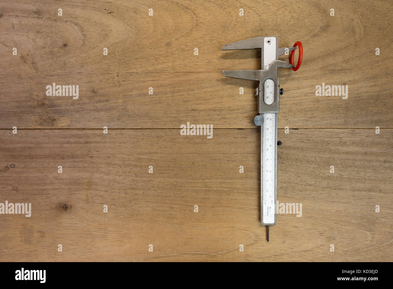Vernier caliper with red ring on wooden background, flat lay Stock Photo