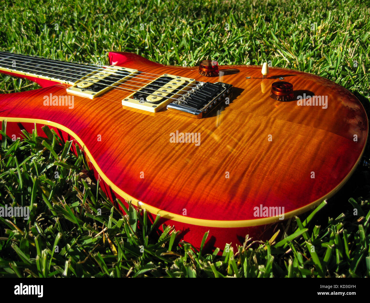 PRS Flame maple cherry burst guitar glowing in the afternoon sun. Stock Photo