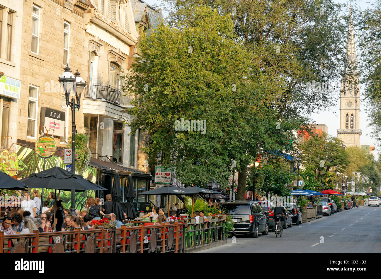 People sitting and talking in outdoor restaurants and bistros on Rue Saint Denis street, Latin Quarter, Quartier Latin, Montreal, Quebec, Canada Stock Photo
