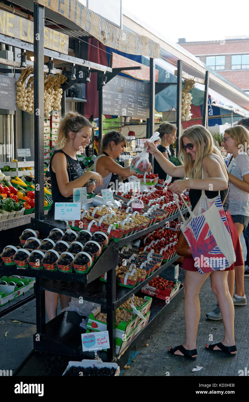 Young woman shopping at a fruit vendor's stall in the Jean Talon public market or Marche Jean Talon, Montreal, Quebec, Canada Stock Photo
