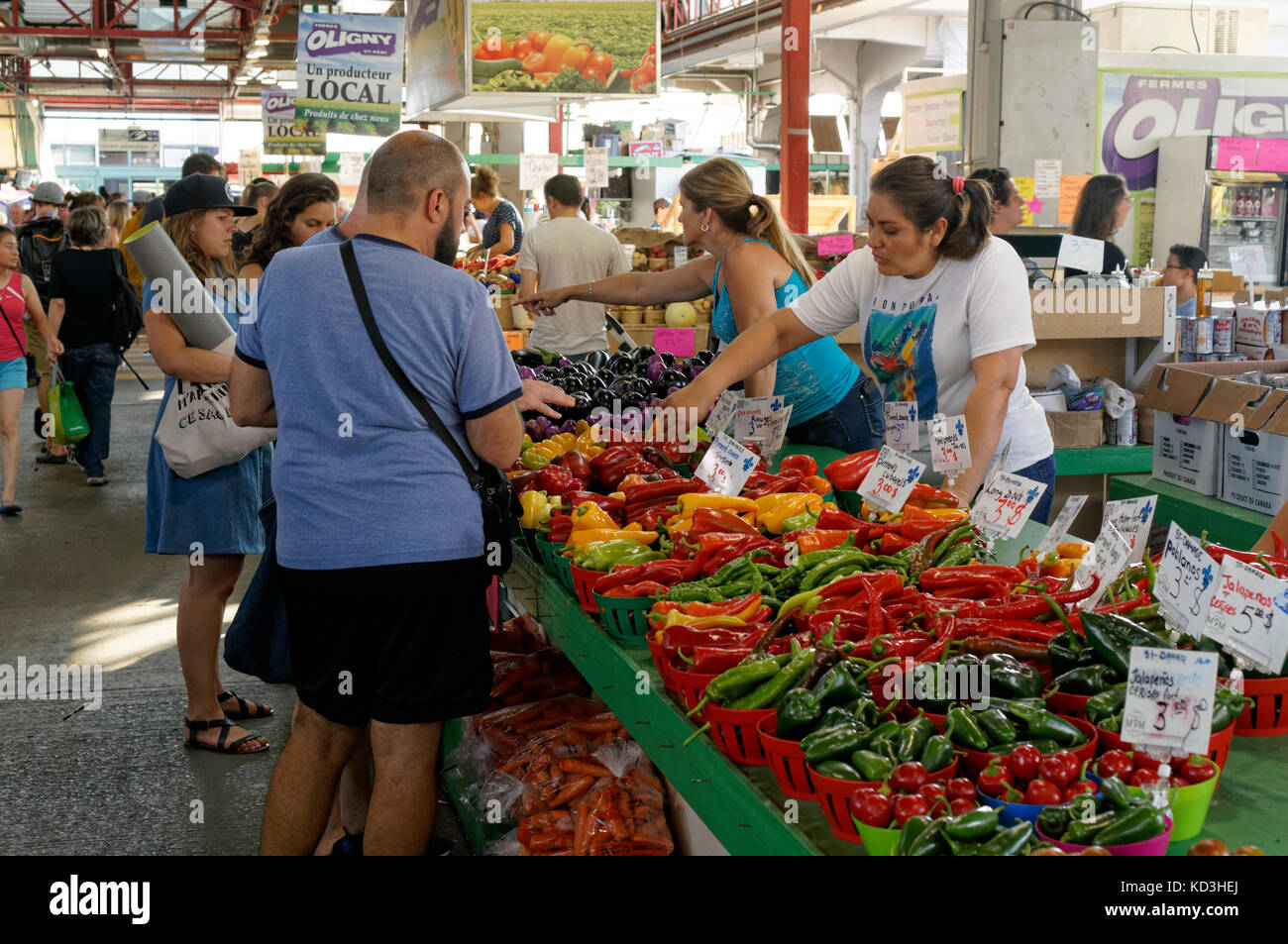 People shopping at a vegetable vendor's stall in Jean Talon public market or Marche Jean Talon, Montreal, Quebec, Canada Stock Photo