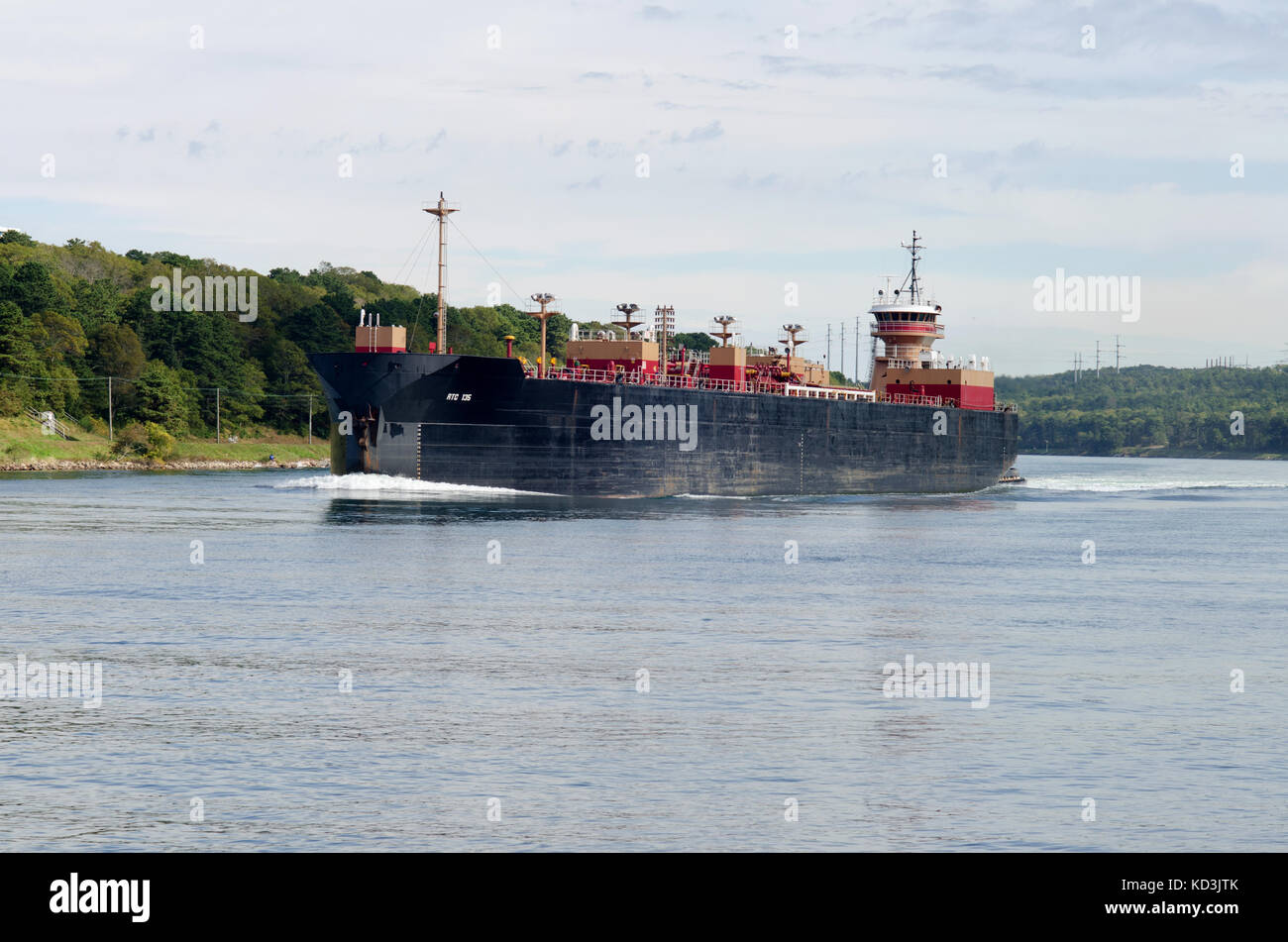 Fuel barge navigating  in Cape Cod Canal by being pushed by tugboat, USA Stock Photo