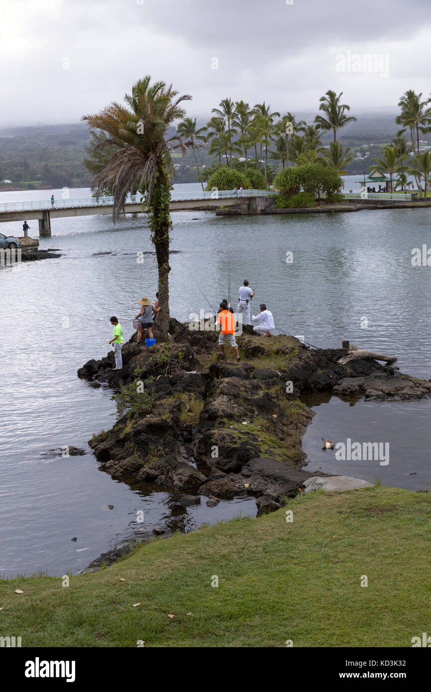 Fishermen fishing the calm waters of Hilo Bay at dusk, with a view of Coconut Island. Stock Photo